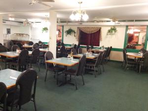 uma sala de jantar com mesas e cadeiras de madeira em Shamrock Motel em Valleyview