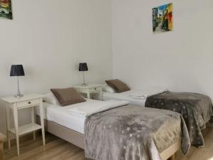 1 dormitorio con 2 camas y 2 mesitas de noche en Studio Dymińska, en Varsovia