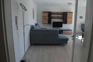 ein Wohnzimmer mit einer blauen Couch und einem Fernseher in der Unterkunft City-Apartment Bad Schussenried in Bad Schussenried