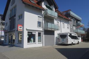 ein weißer LKW, der vor einem Gebäude parkt in der Unterkunft City-Apartment Bad Schussenried in Bad Schussenried