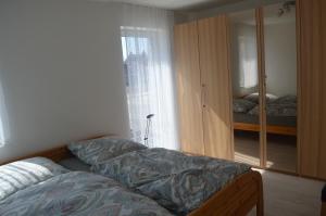 ein Schlafzimmer mit einem Bett, einem Schrank und einem Fenster in der Unterkunft City-Apartment Bad Schussenried in Bad Schussenried