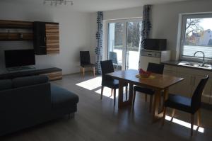 eine Küche und ein Wohnzimmer mit Tisch und Stühlen in der Unterkunft City-Apartment Bad Schussenried in Bad Schussenried