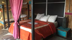 a bedroom with a bed with an orange blanket at Paraiso Lounge in Santa Marta