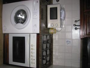 uma cozinha com uma máquina de lavar roupa e um micro-ondas em Moledo Beach - Guest Apartment em Moledo