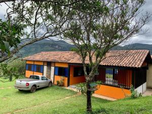 a house with a car parked in front of it at Estâncias da Serra dos Alves in Itabira