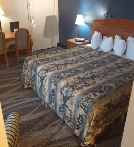 une chambre d'hôtel avec un lit et une table dans l'établissement Rochester Inn, à Rochester