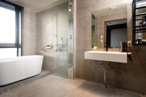 uma casa de banho com um lavatório, uma banheira e um espelho. em Joytel Hotel Osaka Shinsekai em Osaka
