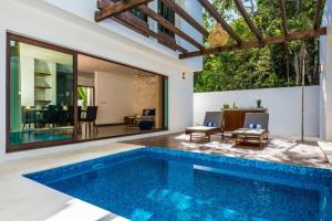 einen Pool in einem Haus mit einem Wohnzimmer in der Unterkunft Tranquil villa with pool and chef services 4BR 8ppl in Tulum