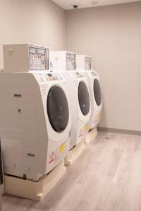 una fila de lavadoras blancas en una habitación en Hotel Keihan Nagoya en Nagoya