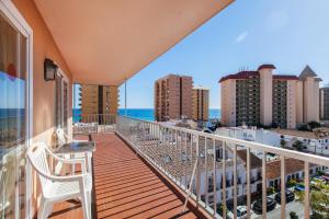 Un balcón con una silla y vistas al océano. en Apartamentos Embajador, en Fuengirola