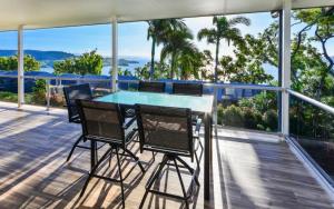 a deck with a table and chairs on a balcony at Blue Water Views on Hamilton Island by HIHA in Hamilton Island