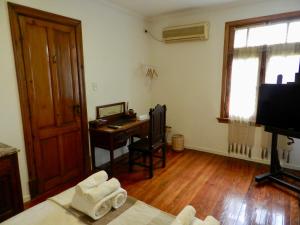 um quarto com uma secretária e uma cama com toalhas em B&B Polo em Buenos Aires