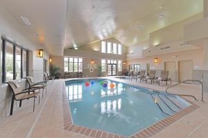 een zwembad in een hotel met stoelen en tafels bij Holiday Inn Express Hotel & Suites Gillette, an IHG Hotel in Gillette