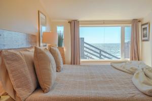 a bedroom with a large bed with a large window at Surfscape Beach House, Private Beach & Ocean views in Bodega Bay