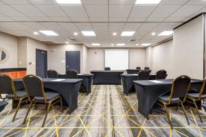 a conference room with tables and chairs and a screen at Holiday Inn Allentown-Bethlehem by IHG in Allentown