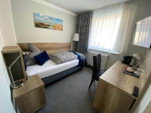 um quarto de hotel com uma cama e uma secretária em Hotel Mocca-Stuben em Helgoland