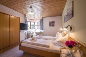 a bedroom with two beds and a table with flowers at Gasthaus Kammerhof in Angath