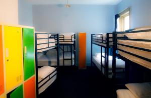a room with three bunk beds in it at Backpackers Imperial Hotel in Hobart