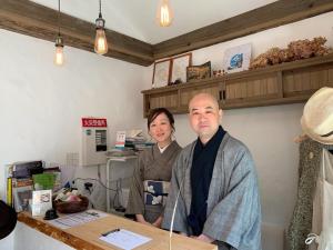 a man and a woman standing next to a table at Kyono Mori Yurinsha in Kyoto