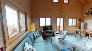 Alpenlodge في بيلالب: غرفة معيشة مع أريكة زرقاء وتلفزيون