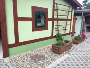 a small house with two potted plants and a window at Fewo Ramin in Felchow