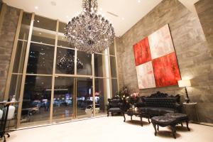 a lobby with chairs and a chandelier and a building at Ashley Sabang Jakarta in Jakarta
