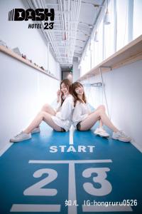 two girls are sitting on a sign in a building at Dash 23 Hotel in Tainan