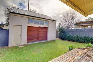 a house with a garage with a grass yard at Adelaide close CBD Large Private Studio Apartment in St Peters in Norwood