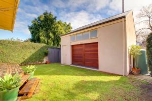 a house with a garage with a grass yard at Adelaide close CBD Large Private Studio Apartment in St Peters in Norwood