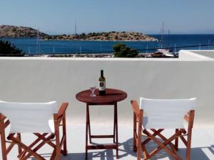 una mesa con una botella de vino y dos sillas en Blue Diamand, en Mégara