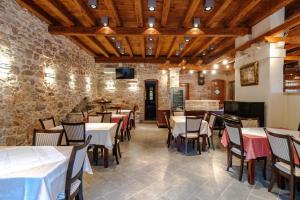 un restaurante con mesas y sillas y una pared de piedra en Rooms Miron - Adults Only en Sumartin