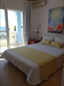 a bedroom with a large bed and a large window at Blue Diamand in Megara