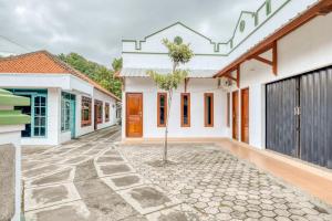 un patio de una casa con un árbol en el medio en RedDoorz near Wisata Pantai Parangtritis, en Kretek