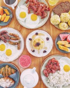 Crimson Resort and Spa - Mactan Island, Cebu في ماكتان: طاولة مع أطباق من البيض وأطعمة الإفطار الأخرى