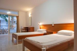 Una habitación de hotel con dos camas y balcón. en Coliseum Studios & Apartments, en Pefki
