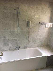 a bath tub in a bathroom with a shower at Value Stay Brussels South in Waterloo