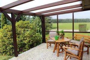 a pergola with a table and chairs on a patio at Ferienhaus Frado in Briesen