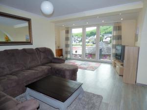 a living room with a couch and a tv at Ferienhaus Moselpromenade in Zell an der Mosel