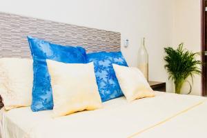 a bed with blue and white pillows on it at Superior Studio 20 Aquamarina Suites in Playa del Carmen