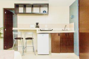 a kitchen with a sink and two bar stools at Superior Studio 20 Aquamarina Suites in Playa del Carmen