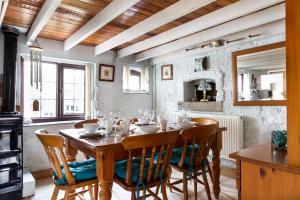 a dining room with a wooden table and chairs at Herefordshire Holiday Cottages in Lea