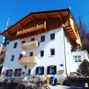 a large white building with wooden balconies on it at Mountain in Alleghe