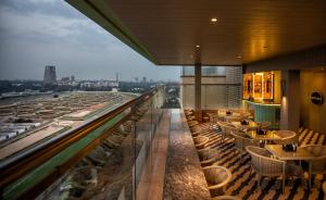 a restaurant with tables and chairs on a roof at Holiday Inn Bengaluru Racecourse, an IHG Hotel in Bangalore