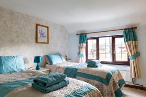 a bedroom with two beds and a window at Herefordshire Holiday Cottages in Lea