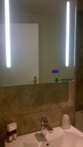 ein Badezimmer mit einem Waschbecken und einem großen Spiegel in der Unterkunft Best Western The Rose & Crown Hotel in Colchester
