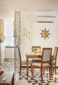 a dining room with a table and chairs at El Arbol by The Blue Kite with Rooftop Pool, Kitchen, Wifi, Security,10 Mins to Candolim Beach & 5 mins to Casino in Panaji