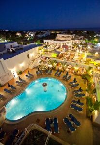 a view of a pool at night with lounge chairs at Pefkos Beach Studios & Apartments in Pefki
