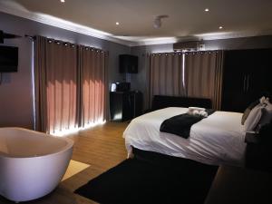 1 dormitorio con cama blanca y bañera en The Green Olive Guesthouse en Bethlehem
