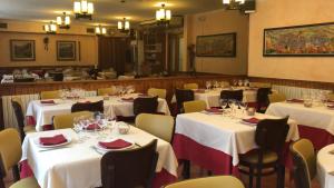 a restaurant with white tables and chairs with wine glasses at Hostal Montaña in Alins