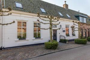 a white building with a tree in front of it at De Heerlijkheid van Noordwelle Adults Only in Renesse
